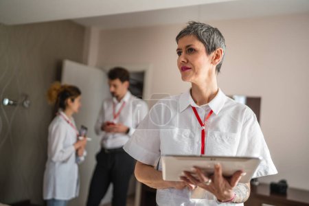 Téléchargez les photos : Une femme entrepreneure chef d'équipe debout devant ses collègues dans la chambre d'hôtel se préparer pour la conférence d'affaires rencontrer des entrepreneurs de personnes réelles copier l'espace - en image libre de droit