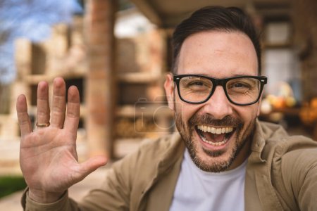 Téléchargez les photos : Un homme caucasien adulte moderne portrait d'homme avec barbe et lunettes heureux confiant à la maison autoportrait selfie UGC contenu généré par l'utilisateur - en image libre de droit