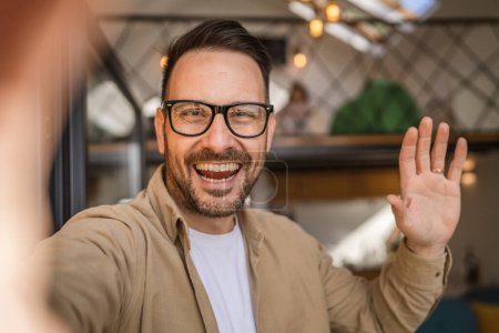 Ein moderner erwachsener kaukasischer Mann Porträt eines Mannes mit Bart und Brille glücklich zuversichtlich zu Hause Selbstporträt Selfie UGC Benutzer generierte Inhalte