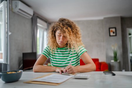 Foto de Mujer caucásica en la calculadora de uso doméstico para calcular gastos e impuestos - Imagen libre de derechos
