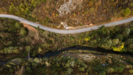 Téléchargez les photos : Vue aérienne du haut vers le bas image de drone sur la route à travers les arbres et la forêt dans la chaîne de montagnes en journée d'automne en Serbie Voyage et vacances concept - en image libre de droit