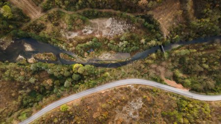 Téléchargez les photos : Vue aérienne du haut vers le bas image de drone sur la route à travers les arbres et la forêt dans la chaîne de montagnes en journée d'automne en Serbie Voyage et vacances concept - en image libre de droit