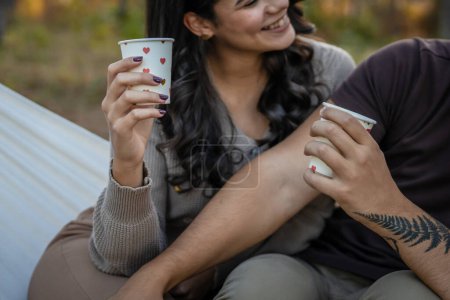 Foto de Joven pareja hombre y mujer novio y novia o marido y esposa en relación de amor mantenga papel taza de café o té mientras pasan tiempo juntos en el parque bosque vinculación amor personas reales - Imagen libre de derechos