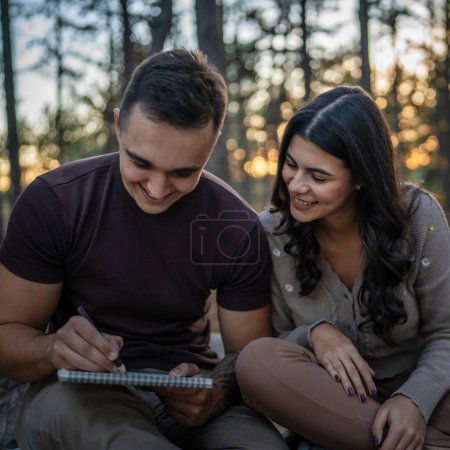 Foto de Hombre y mujer joven pareja adulta en la naturaleza celebrar y dibujar en la naturaleza - Imagen libre de derechos