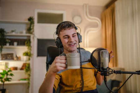 Foto de One man caucasian male blogger or vlogger gesticulating while streaming video podcast in broadcasting studio use microphone and headphones famous influencer shooting video for channel podcast - Imagen libre de derechos