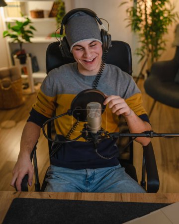 Téléchargez les photos : One man caucasian male blogger or vlogger gesticulating while streaming video podcast in broadcasting studio use microphone and headphones famous influencer shooting video for channel podcast - en image libre de droit