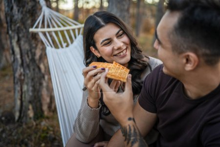 Photo for Couple adult man and woman in love eat waffle in nature park or woods - Royalty Free Image