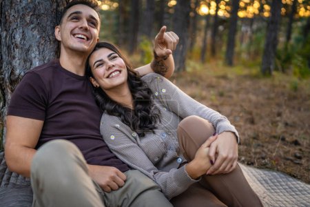 Téléchargez les photos : Homme et femme jeune couple adulte dans la nature en amour assis ensemble - en image libre de droit