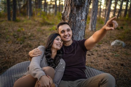 Téléchargez les photos : Homme et femme jeune couple adulte dans la nature en amour assis ensemble - en image libre de droit
