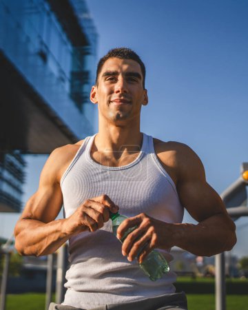 Photo for One man caucasian male athlete hold plastic bottle of water opening and prepare to drink while training outdoor in sunny day hydration and healthy lifestyle concept copy space - Royalty Free Image