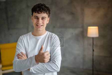 Photo for Portrait of one caucasian man 20 years old looking to the camera at home smiling wearing casual white shirt copy space - Royalty Free Image