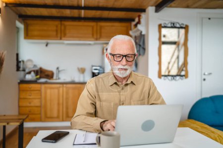 Photo for One senior caucasian man grandfather with beard and eyeglasses work on laptop use computer at home - Royalty Free Image