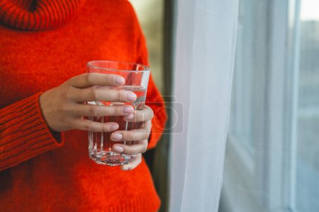 Photo for Close up on midsection of unknown caucasian woman hold glass of water - Royalty Free Image