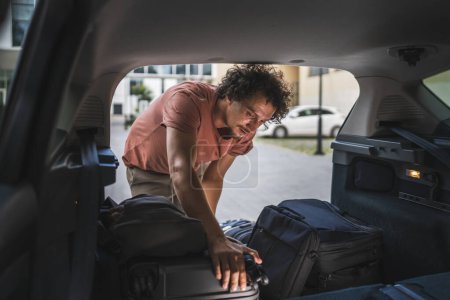 Photo for One adult man travel concept male take stuff belongings from the back or put in trunk of the car while moving to travel or arrive to destination real people copy space - Royalty Free Image