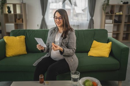 Photo for Pregnant woman hold pills and prescription Expectant mother read leaflet before take a tablets medication or supplement - Royalty Free Image