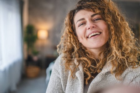 Porträt einer erwachsenen kaukasischen Frau mit lockigem Haar zu Hause glücklich lächeln Selbstporträt Selfie ugc User generierte Inhalte