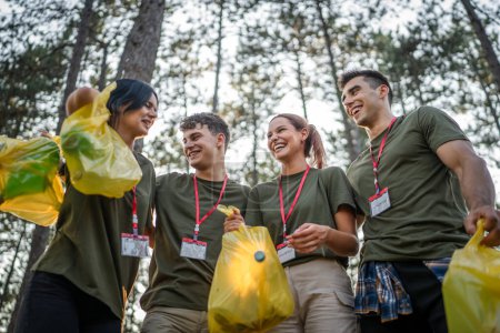 Foto de Retrato del grupo de amigos voluntarios se preparan para recoger residuos de basura y naturaleza limpia del bosque en el día de verano cámara lenta - Imagen libre de derechos