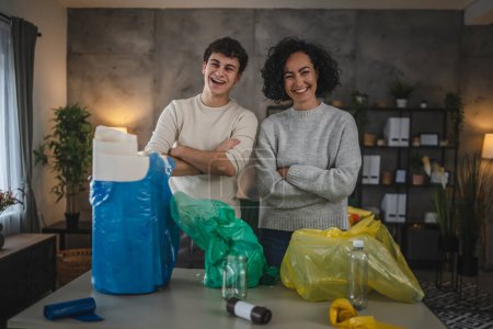 Foto de Madre e hijo mujer y adolescente hombre familia reciclar en casa clasificación de residuos de papel plástico y vidrio a bolsas concepto de vida sostenible - Imagen libre de derechos