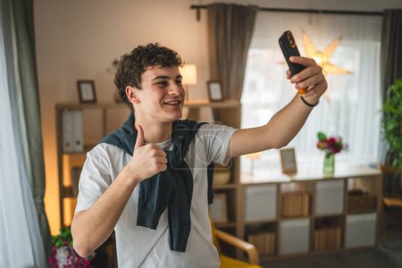 Foto de Un hombre adolescente de pie en casa tienen un teléfono inteligente de teléfono móvil de uso de llamada - Imagen libre de derechos