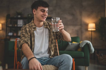Photo for Portrait of man young caucasian male teenager hold glass of water at home - Royalty Free Image