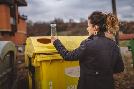 Photo for One adult woman stand with plastic waste and yellow bags in front of recycle containers throwing bottle for reuse zero waste eco concept - Royalty Free Image
