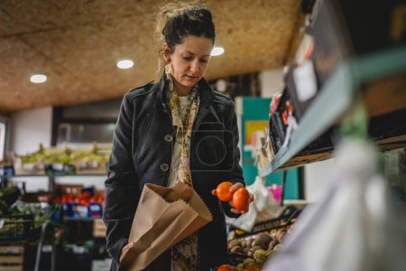 Photo for Woman grocery shopping at the local store with paper bag - Royalty Free Image