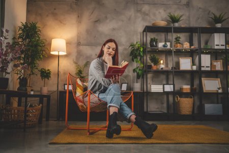 Foto de Mujer adulta joven una estudiante femenina leer libro o estudiar en casa rojo espacio de copia de pelo - Imagen libre de derechos