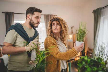 Téléchargez les photos : Couple caucasien homme et femme femme femme et mari plantation de fleurs ensemble prendre soin de plantes à la maison personnes réelles concept de famille de la vie familiale - en image libre de droit