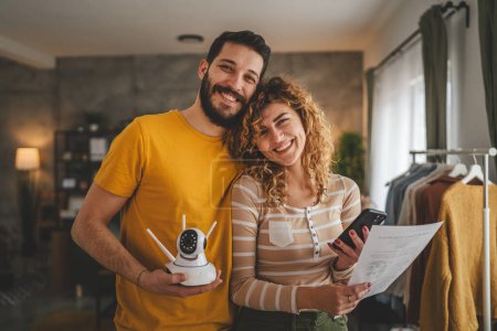 Téléchargez les photos : Couple à la maison connecter et installer la caméra de surveillance de sécurité cctv - en image libre de droit