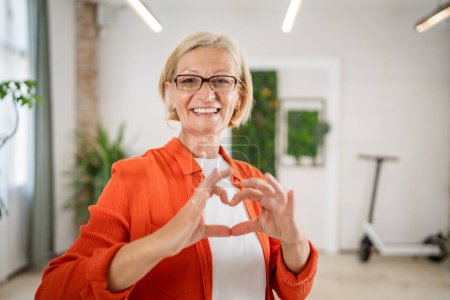 Photo for Portrait of one mature blonde caucasian woman with eyeglasses in the office at work happy smile looking to the camera confident copy space - Royalty Free Image