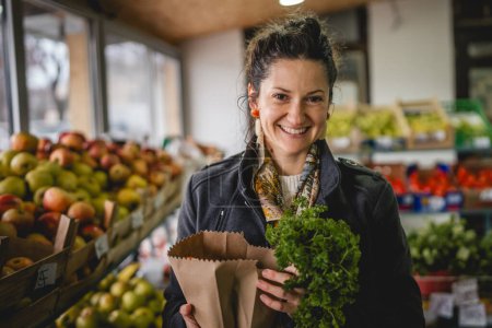 Porträt einer Frau hält Bio-Obst und -Gemüse in Papiertüte