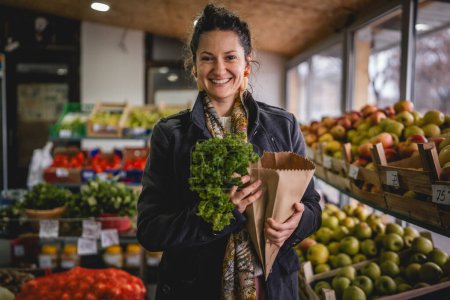 Téléchargez les photos : Portrait d'une femme tenant des fruits et légumes biologiques dans un sac en papier - en image libre de droit