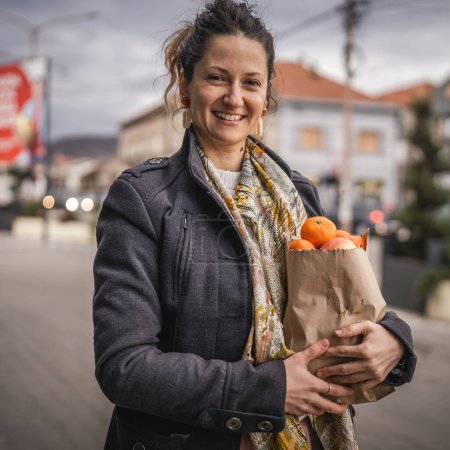 Foto de Retrato de una mujer sostiene frutas y verduras orgánicas en bolsa de papel - Imagen libre de derechos