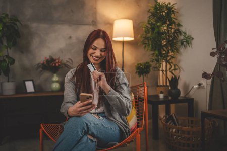 Photo for Young woman caucasian female hold credit card online shopping at home - Royalty Free Image