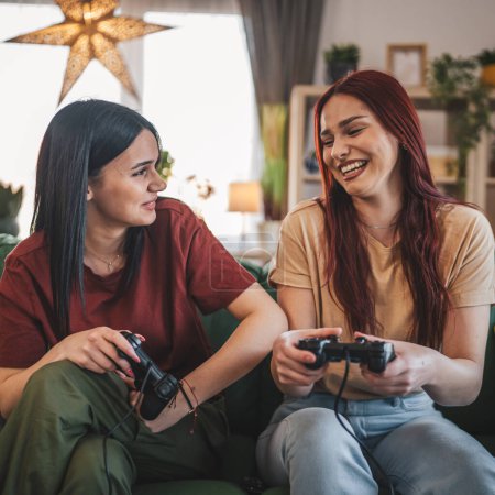 Photo for Two young women caucasian friends or sisters play console video game - Royalty Free Image