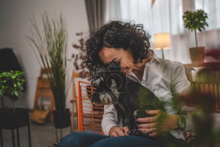 Photo for Portrait of adult caucasian woman mature female with pet dog at home - Royalty Free Image