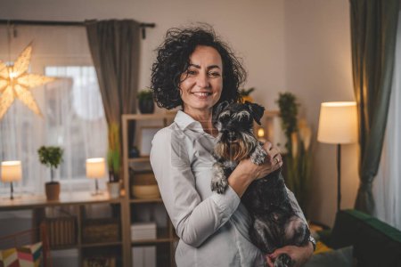 Téléchargez les photos : Portrait de femme adulte caucasienne mature femelle avec chien de compagnie à la maison - en image libre de droit