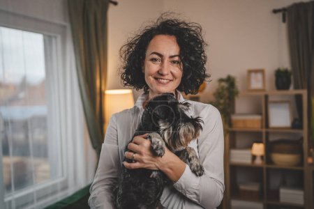 Téléchargez les photos : Portrait de femme adulte caucasienne mature femelle avec chien de compagnie à la maison - en image libre de droit