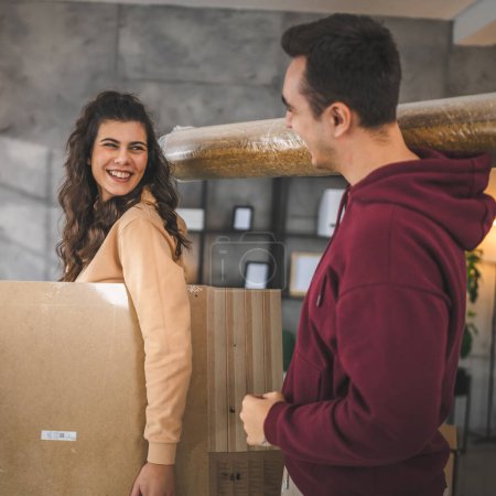 Photo for Young couple moving in new apartment carry assembly furniture - Royalty Free Image