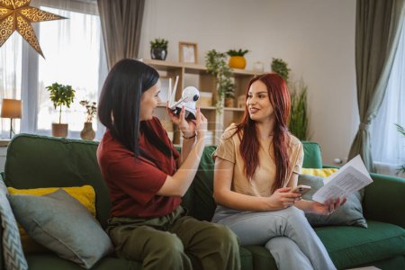Téléchargez les photos : Deux femmes sœurs ou amis colocataires à la maison appartement connecter et installer cctv caméra de surveillance de sécurité - en image libre de droit