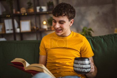 Foto de Joven caucásico adolescente leer libro estudio en casa educación concepto - Imagen libre de derechos