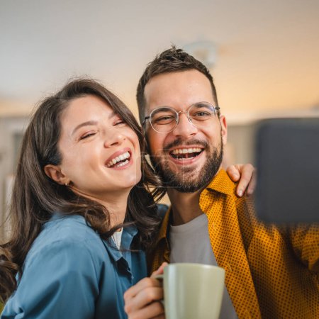 Foto de Autorretrato selfie de feliz pareja marido y mujer novio y novia o hermano y hermana feliz sonrisa en casa - Imagen libre de derechos