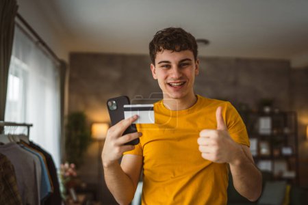 Photo for Teenager young man at home use credit card shopping online - Royalty Free Image