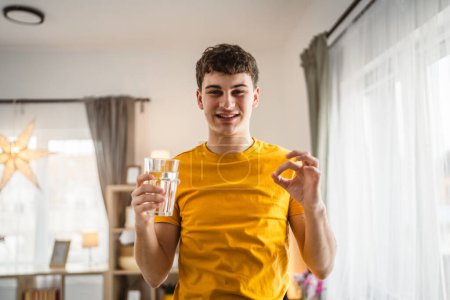 Foto de Hombre joven caucásico macho celebrar vaso de agua en casa - Imagen libre de derechos