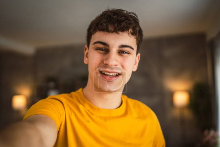 Téléchargez les photos : Portrait de jeune caucasien adolescent mâle jeune homme se tenir à la maison - en image libre de droit
