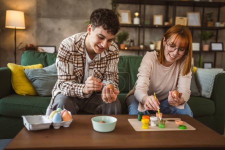 Foto de Joven hombre y mujer pareja o hermano y hermana pintar huevos de Pascua - Imagen libre de derechos