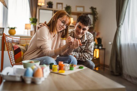 Photo for Young man and woman couple or brother and sister paint easter eggs - Royalty Free Image