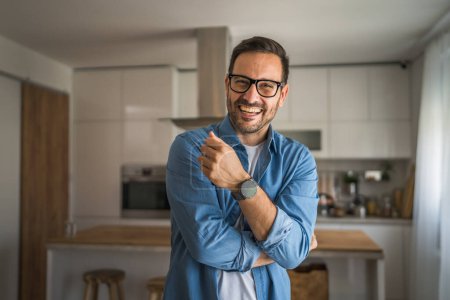 Téléchargez les photos : Un homme adulte portrait de caucasien mâle avec barbe et lunettes se tenir à la maison heureux sourire copie espace - en image libre de droit