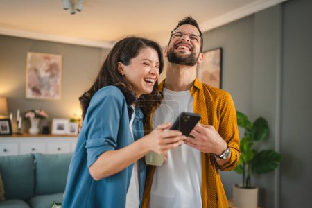 Téléchargez les photos : Adulte couple homme et femme mari femme ont une tasse de café utiliser téléphone mobile recherche internet réseau social heureux sourire - en image libre de droit