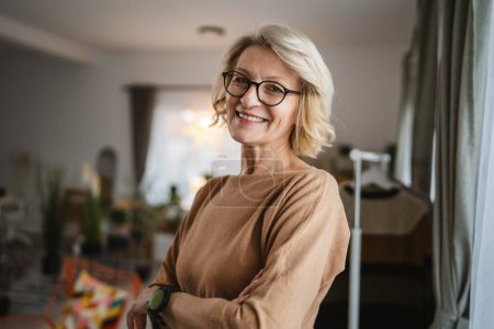 Photo for Portrait of one mature blonde caucasian woman with eyeglasses at home - Royalty Free Image
